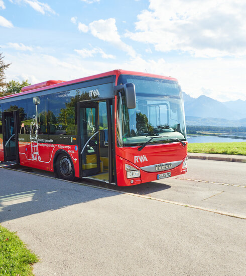 Foto eines Nahverkehrs-Busses mit dem Forggensee und den Ammergauer Alpen im Hintergrund