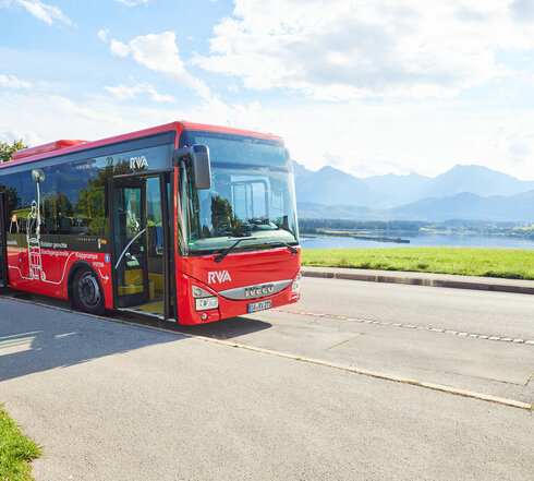 Foto eines Nahverkehrs-Busses mit dem Forggensee und den Ammergauer Alpen im Hintergrund