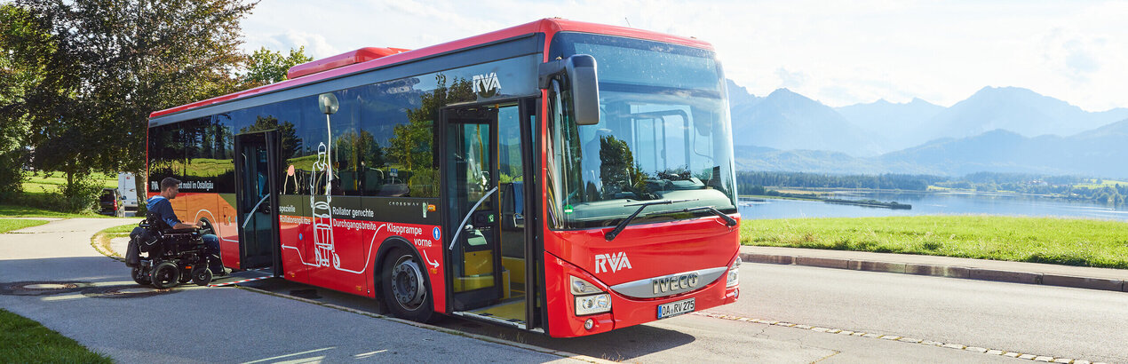 Foto eines Nahverkehrs-Busses mit dem Forggensee und den Ammergauer Alpen im Hintergrund