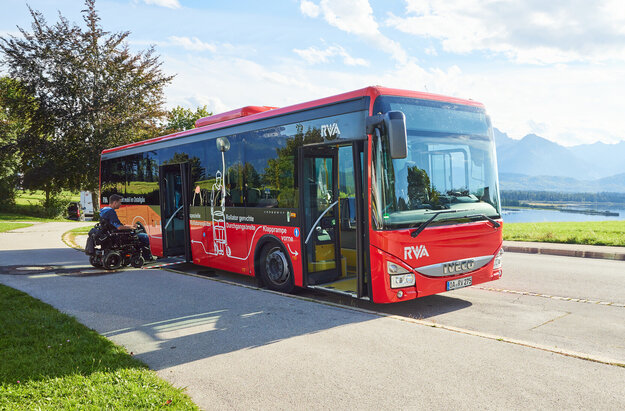 Foto eines Nahverkehrs-Busses mit dem Forggensee und den Ammergauer Alpen im Hintergrund