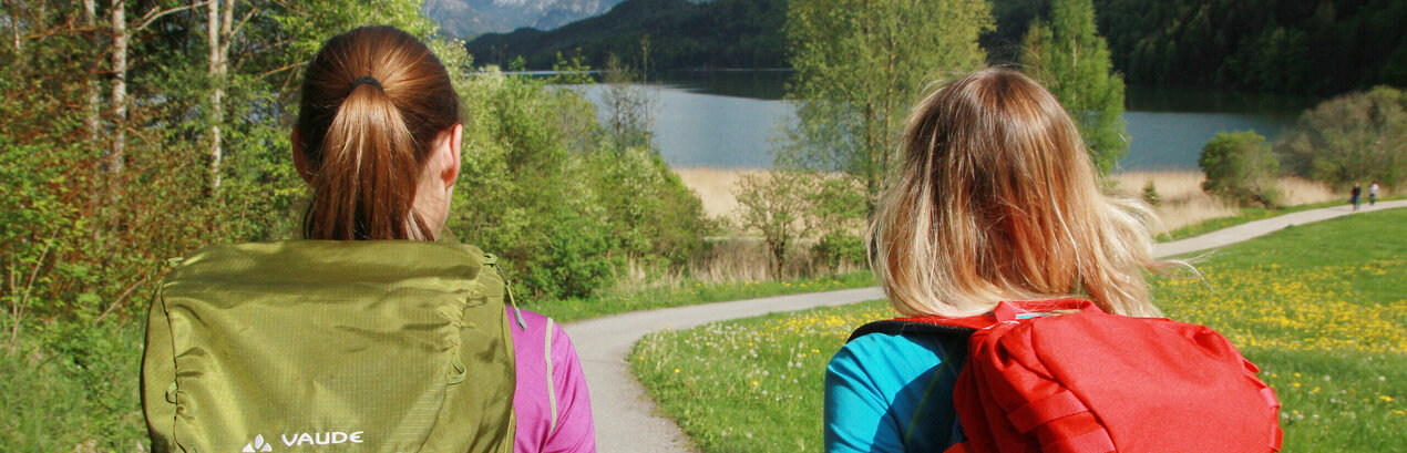 Ein Paar wandert entlang des Weißensees bei Füssen in der Löwenzahnblüze