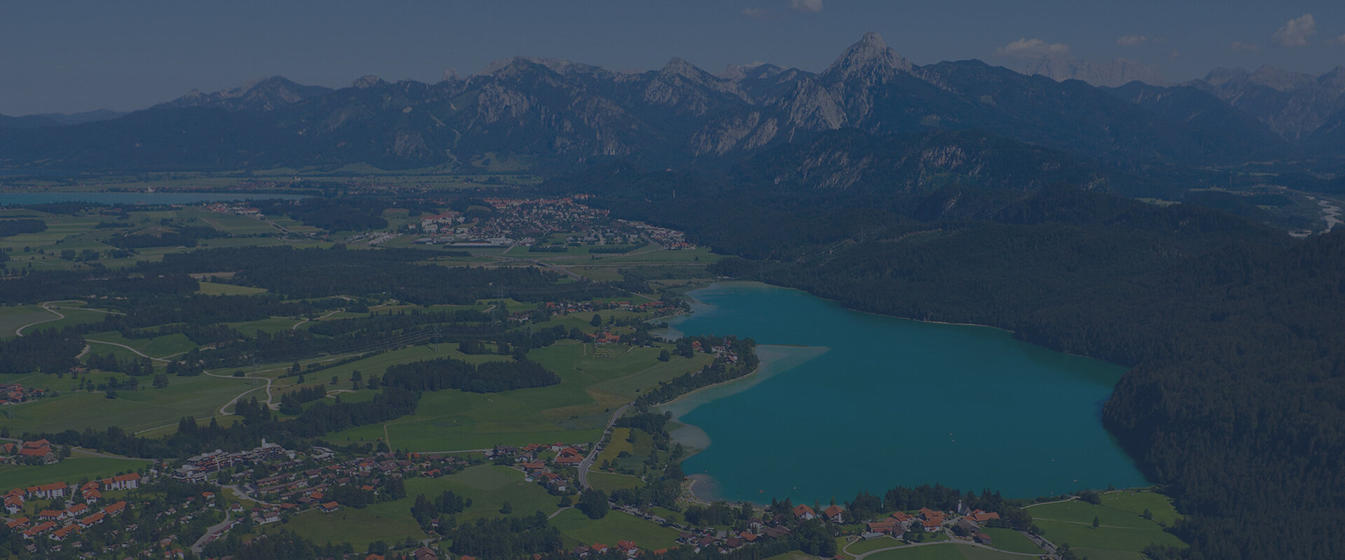 Hintergrundbild: Luftbild von Füssen mit Ammergebirge, Weißensee und Forggensee, Foto: ARW Design Hintergrundbild: Luftbild von Füssen mit Ammergebirge, Weißensee und Forggensee